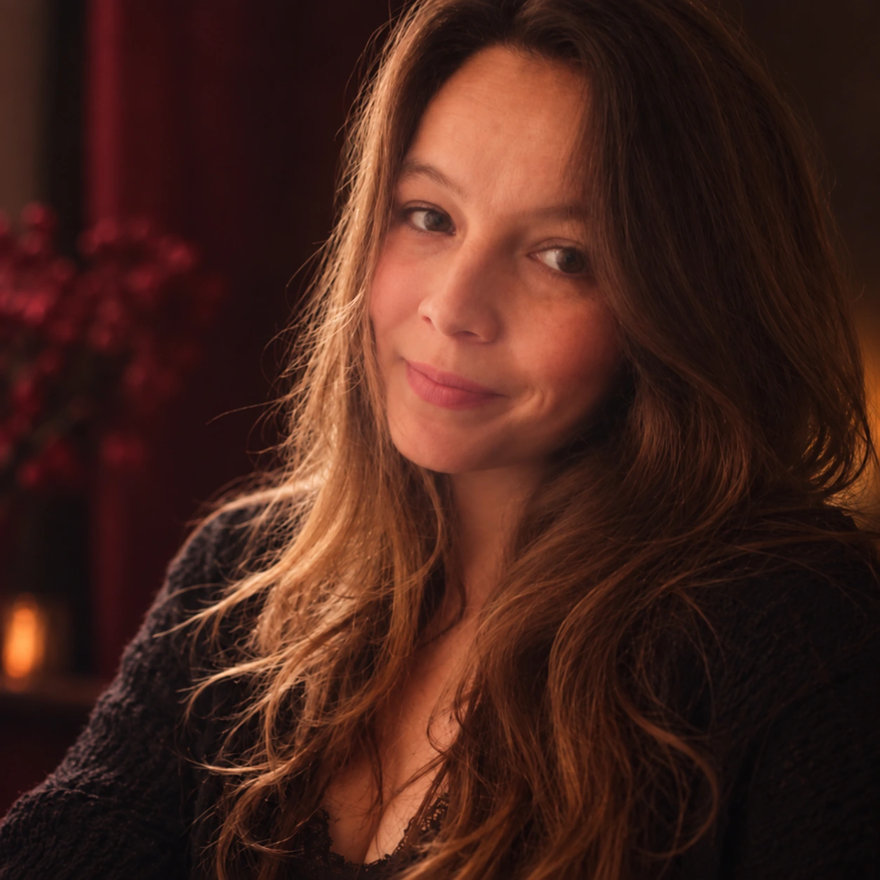 Portrait of author Gilly Rose in warm light against a dark burgundy background.
